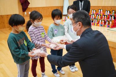 米津社長から「もものパン」を受け取る園児